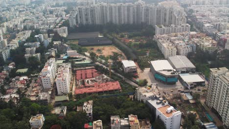 An-aerial-view-of-a-busy-intersection-and-a-construction-site-in-Electronic-City,-Bengaluru,-Karnataka's-Neeladri-Road,-a-popular-destination-for-nightlife-surrounded-by-apartments