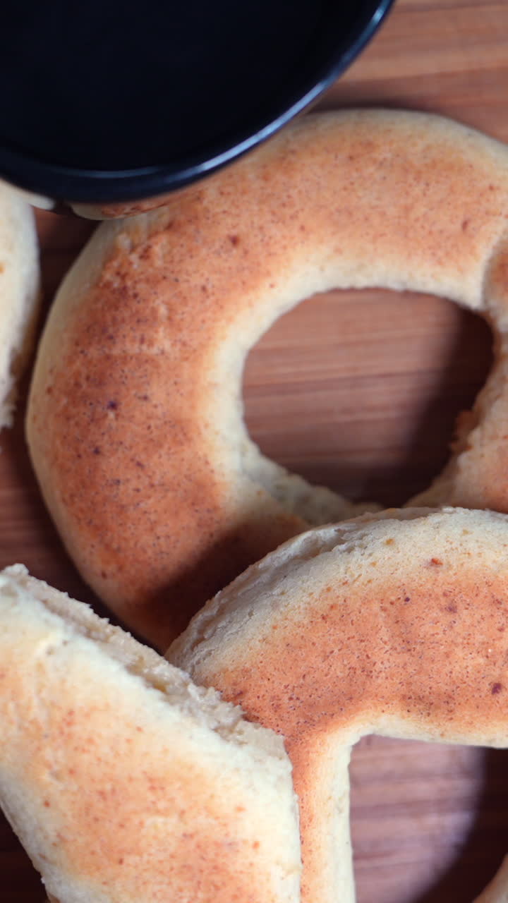 Close-up vertical video featuring golden pandebonos and rich black coffee from Valle del Cauca. Bright lighting enhances the texture, perfect for mobile and social media content