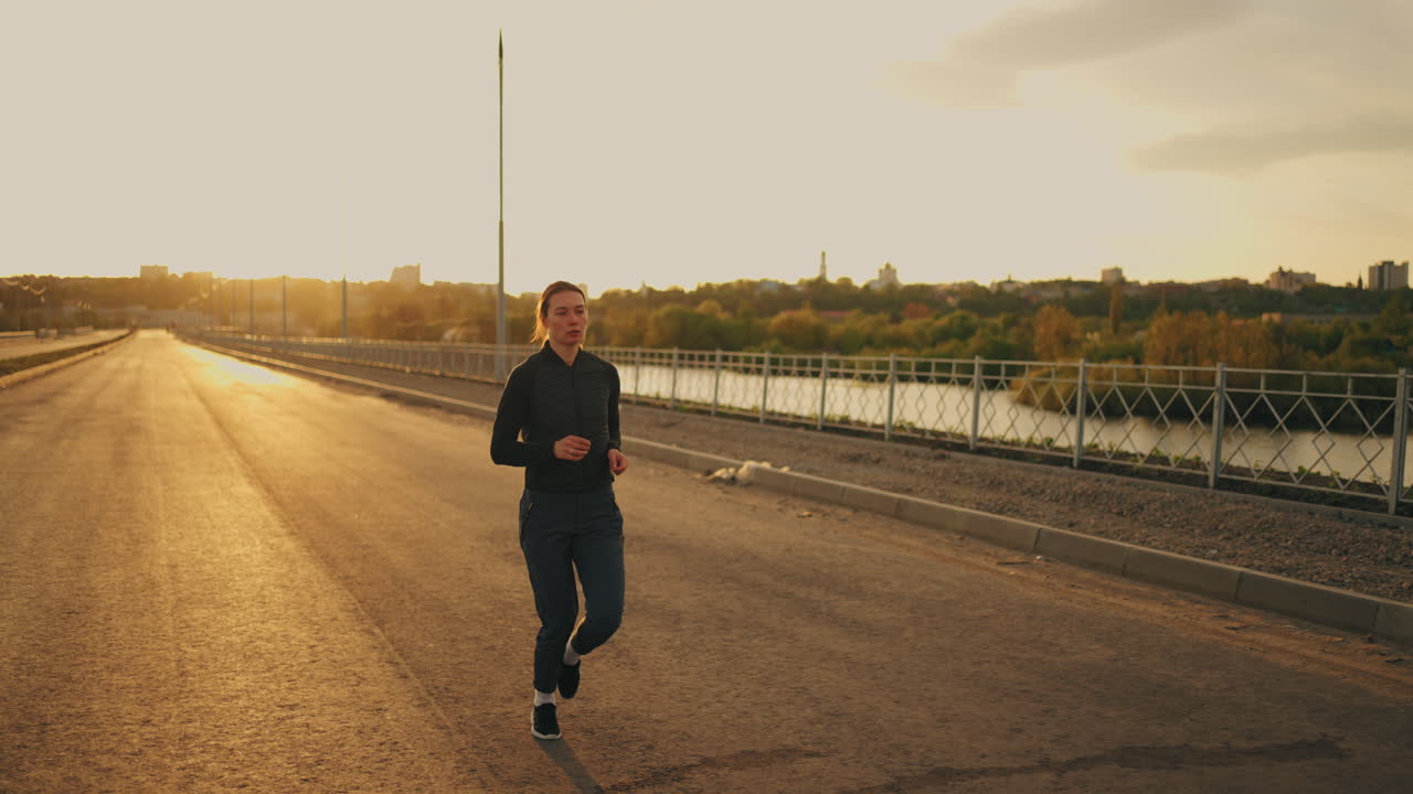 mujer atlética está corriendo sola en la carretera en la mañana de verano o la noche de entrenamiento en tiempo soleado