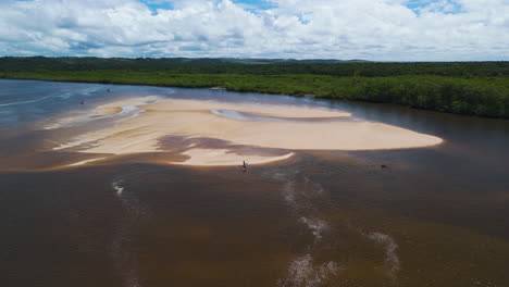 aerial view of a river with a sandbar and people in a boat