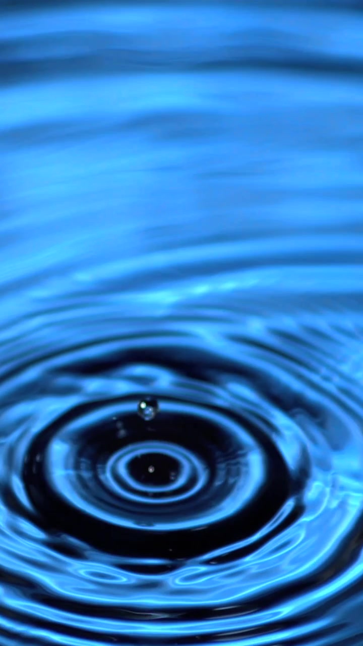 Animation von Wassertropfen, die in blaues Wasser mit leuchtendem Licht fallen