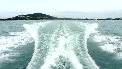 satisfying and symmetrical wake from a passenger boat speeding away from a tropical island