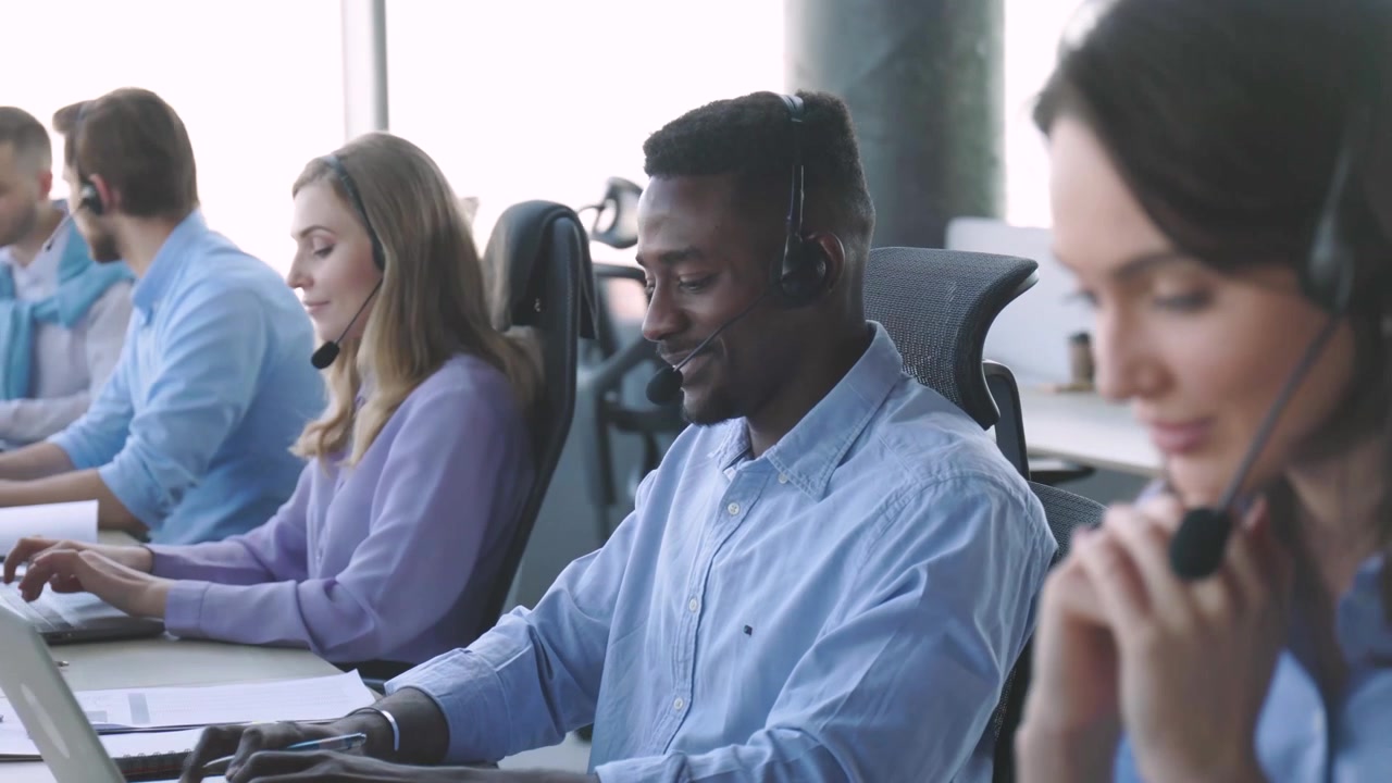 Diverse Call Center Agents Working with Headsets in Modern Office