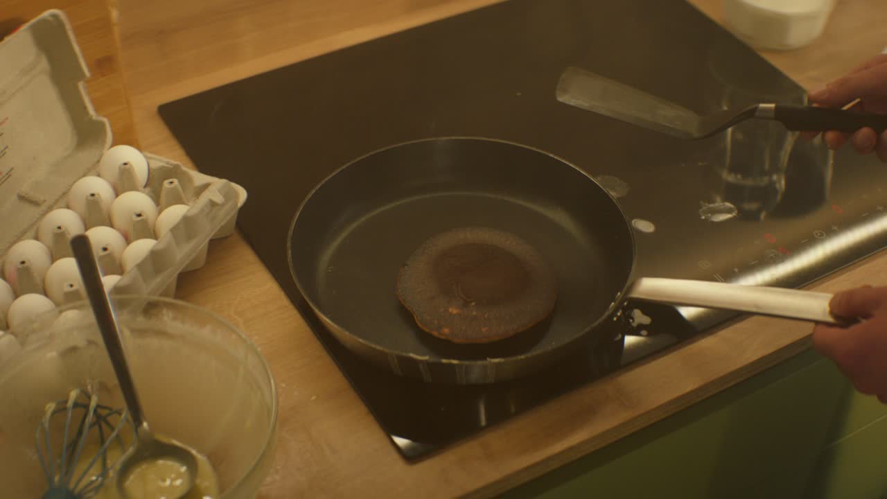 팬케이크가  위에 불타서 남자의 손은 팬케이크는 반대편으로 돌립니다.