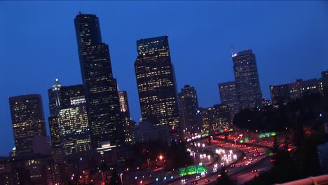 an angled view of seattle's downtown skyline at night with traffic