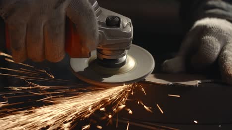cerrajero limpia los bordes de un detalle metálico con un molinillo eléctrico con muchas chispas en cámara lenta, trabajo de metal en el taller, 4k 60p prores hq