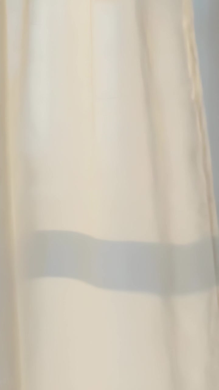 Vertical video: Shifting sunlight moving sheer curtain by window, revealing frame shadow and band