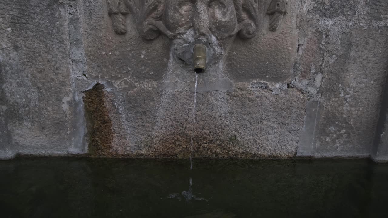 agua que fluye de la fuente de la pared en piedra, pueblo de monsanto en portugal