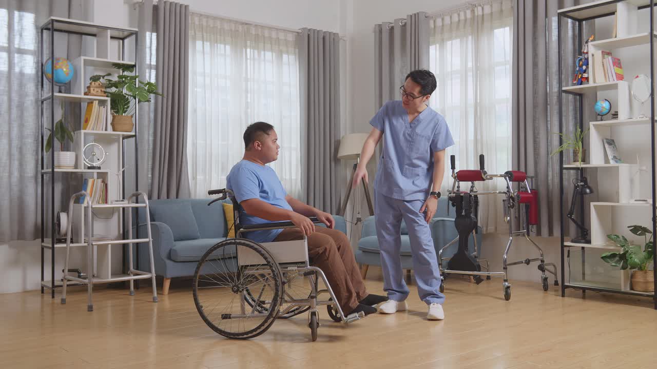 아시안 남성 간호사가 의료 검사 결과에 대해 이야기하고 집에서 물리 치료 후 체어에서 울고있는 환자를 격려합니다.