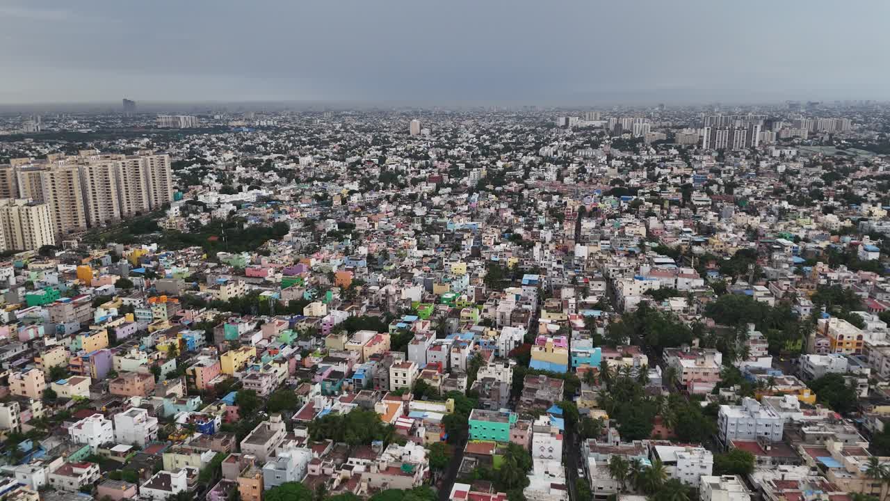 This cinematic aerial footage captures a vast urban sprawl in the late afternoon. Under a moody drizzle, the video is perfect for cityscapes, population density, and the vibrant energy of urban life