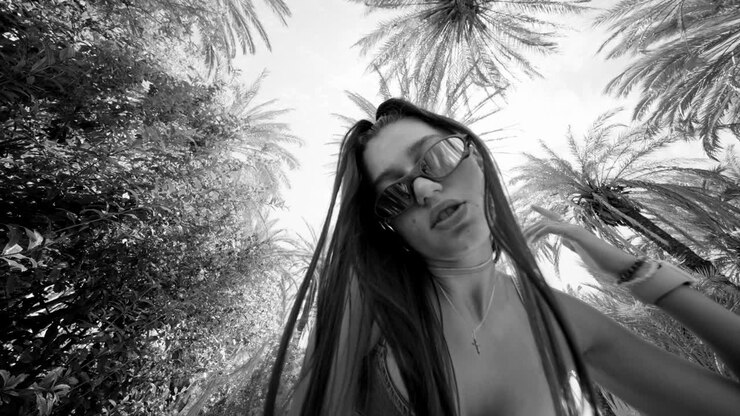 Vedute dal basso di una giovane donna tra le palme