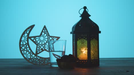 Tracking-Shot-of-a-Lantern-Water-and-Dates-On-Table-During-Dusk-Ramadan-Celebrations