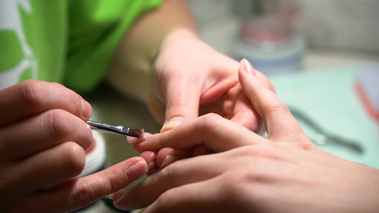 A beautician to a young womans nails