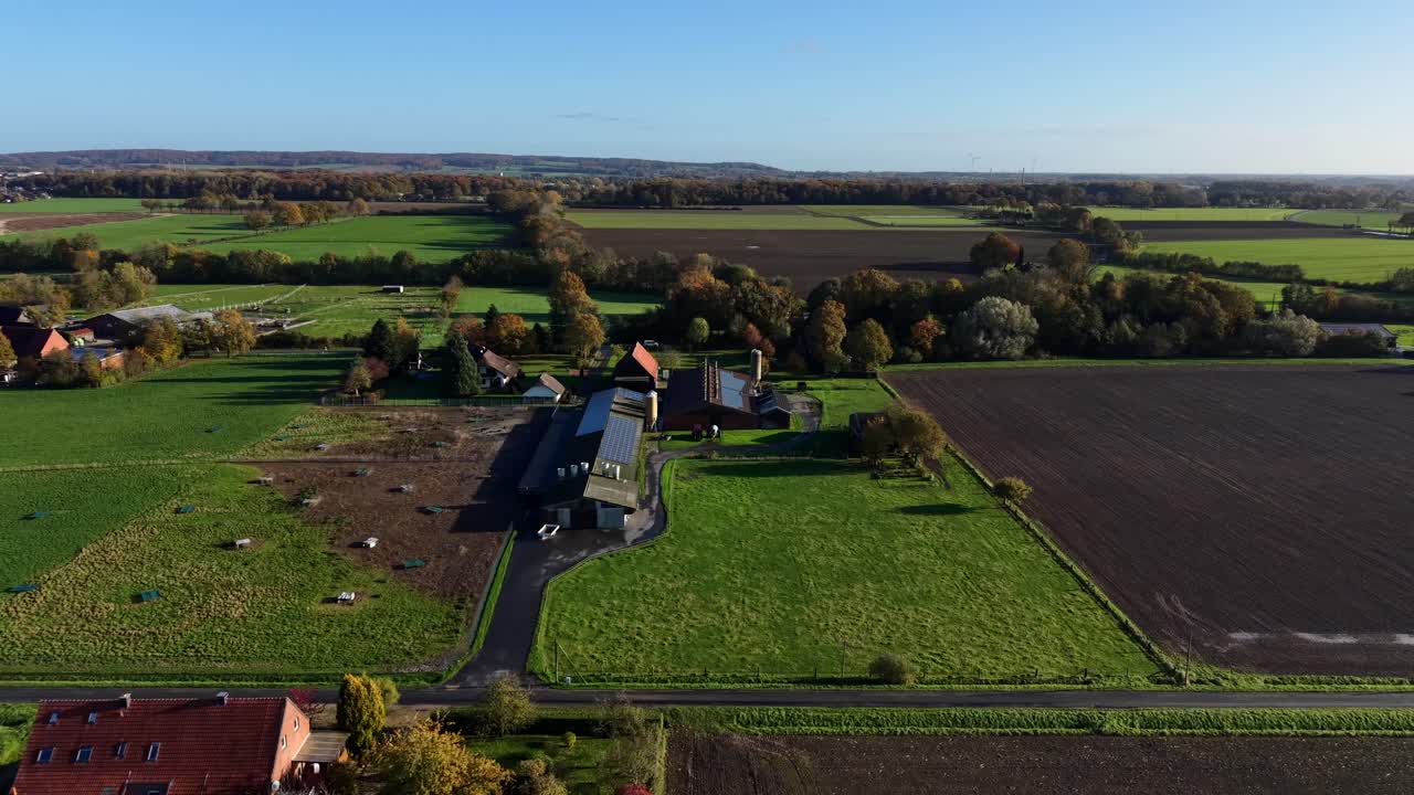Aerial lateral shot of traditional American farm with modern barns, silos and well-maintained outbuildings. rural architecture and agricultural landscapes in usa.Silo storage and stable. Solar on roof