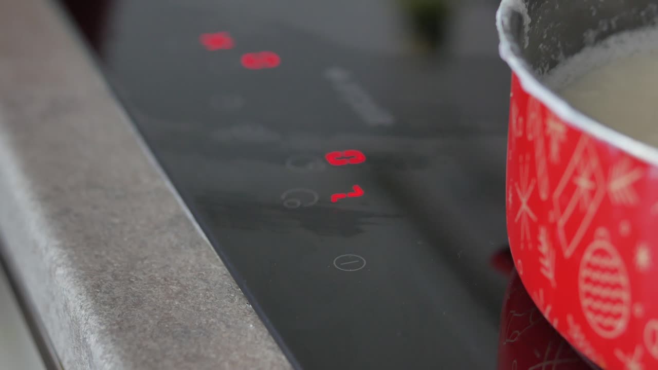 Person Adjusting Temperature on an Electric Stovetop