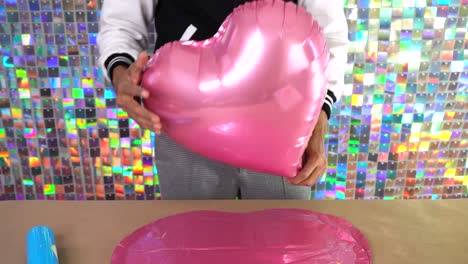 filling up heart shaped balloons, party decorations
