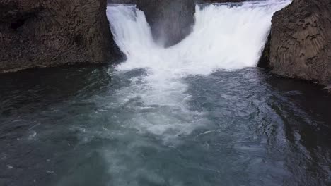 Faszinierende-Statische-Luftaufnahme-Von-Zwei-Wasserfällen,-Die-Mit-Einer-Kraftvollen-Strömung-Ins-Meer-In-Island-Stürzen