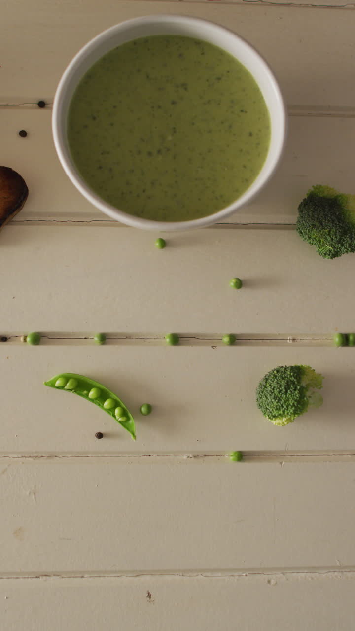 Video verticale di zuppa di piselli cremosa e broccoli su superficie di legno