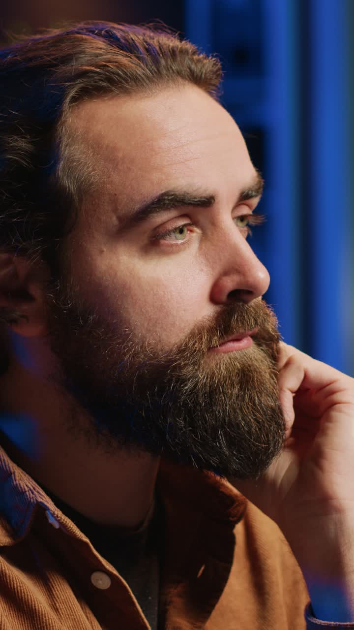 Primo piano di un uomo pensieroso con la barba concentrato di notte
