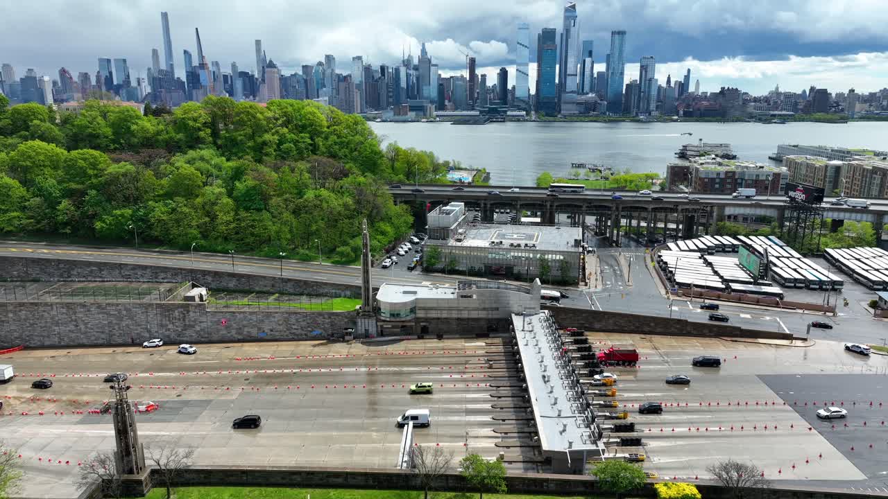 뉴욕 시내 풍경과 초고층 빌딩이 드러나는 허드슨 강 아래의 터널의 통행료 광장
