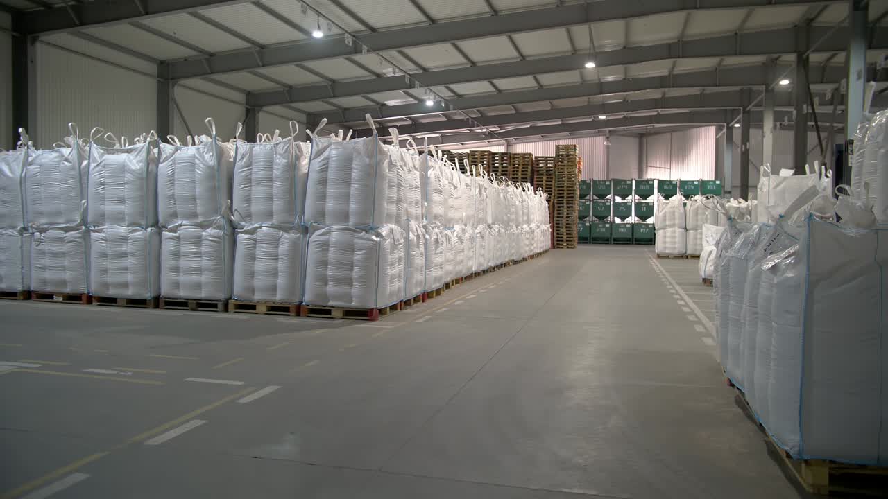 сельскохозяйственное хранилище. склад. мешки с семенами кукурузы, зерном. большой склад сельскохозяйственного предприятия для закупки и хранения семян