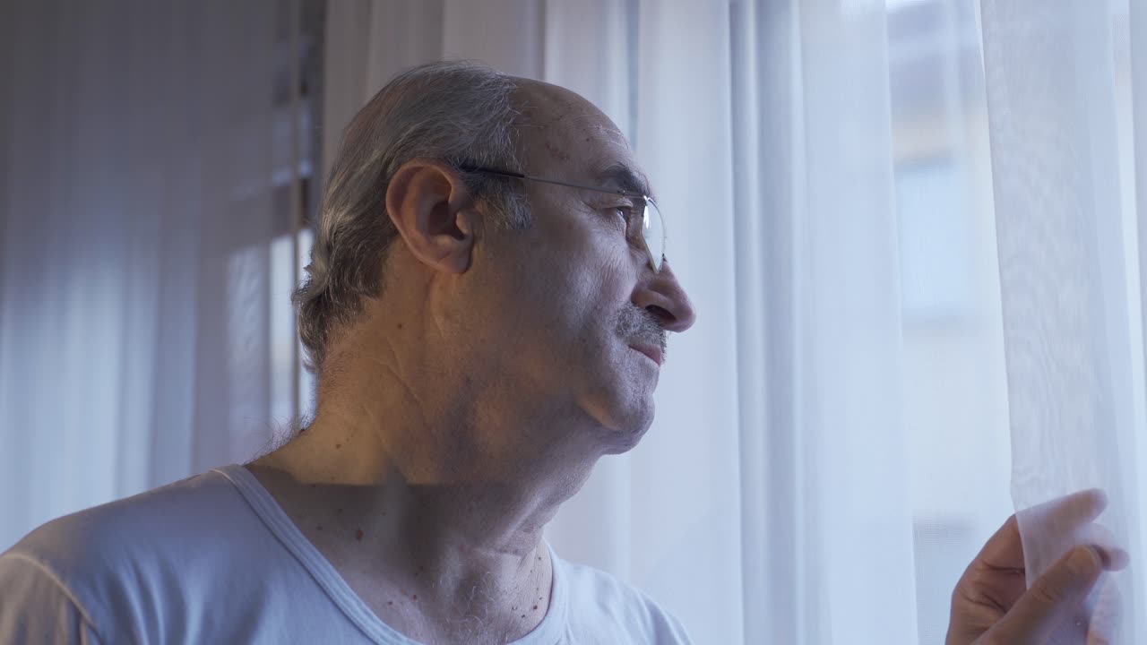 집의 거실 창문을 바라보는 불행한  ⁇ 은이가 안경을 벗습니다.