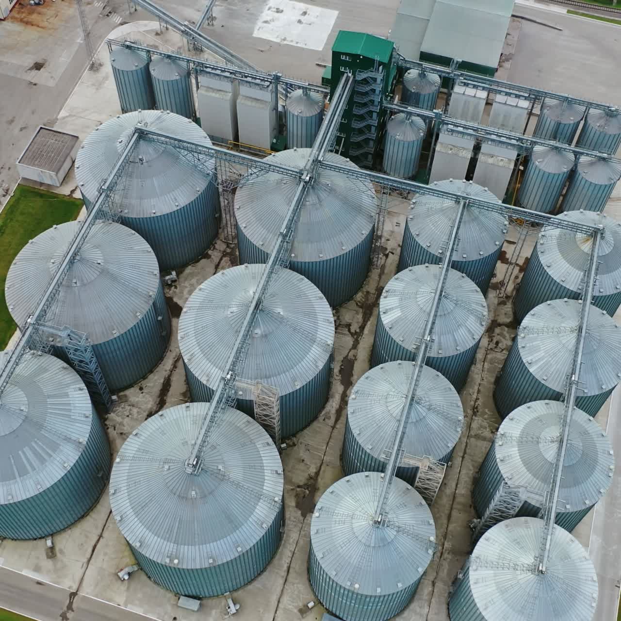 Metal containers for grain storage. Modern grain silos elevator on field. Agricultural granary for farming industry. Top view.
