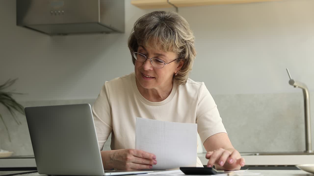mujeres jubiladas revisan papeles cuentan facturas de pago usando calculadora portátil