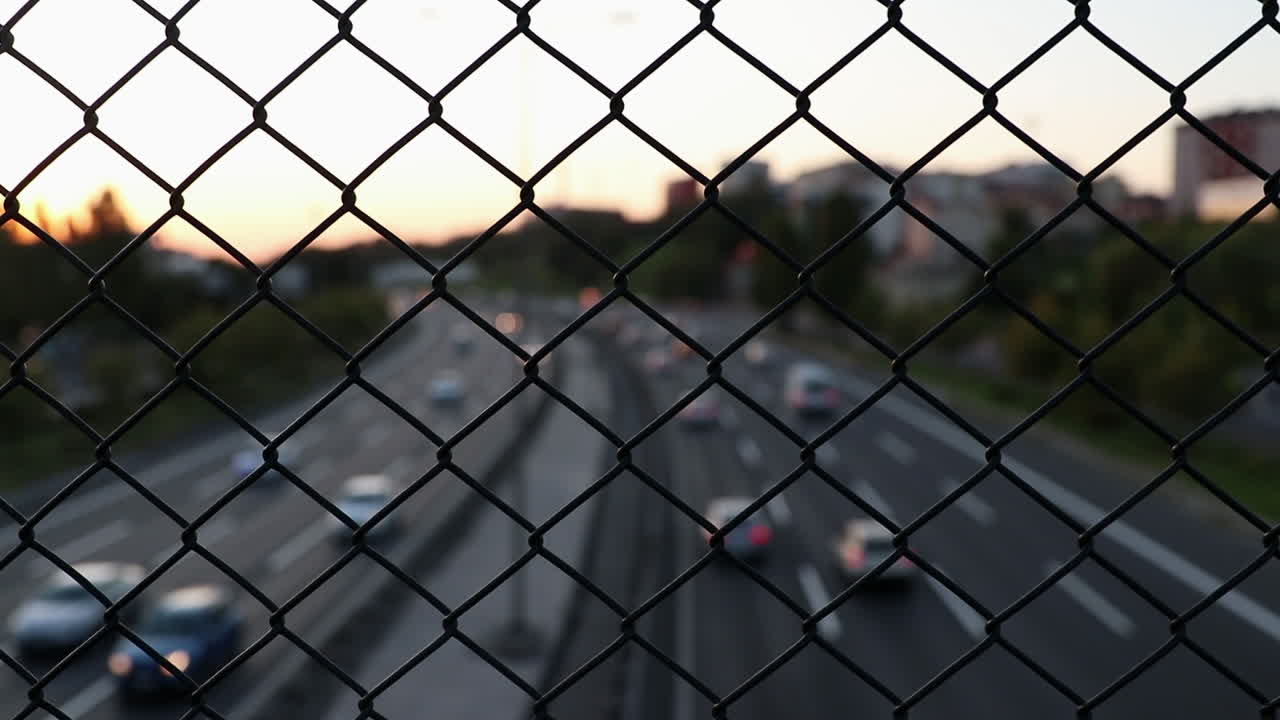 tráfico nocturno detrás de una valla de alambre