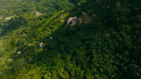 vista aérea persiguiendo un parapente por las montañas y el mar, colombia