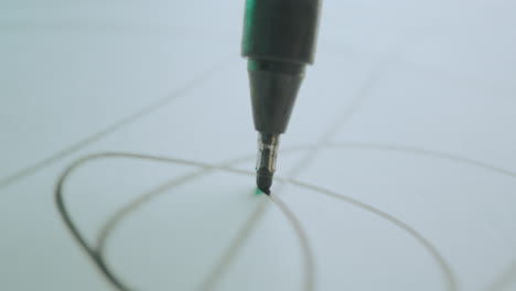 Close-up of a pen drawing lines on paper