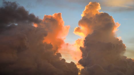 slow-moving cumulonimbus clouds with sunset glowing behind in thailand