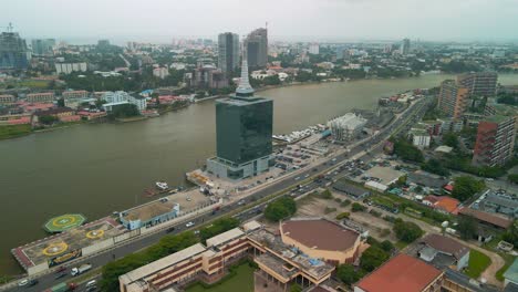 Traffic-and-cityscape-of-Falomo-Bridge,-Lagos-Law-school-and-the-Civic-centre-tower-in-Lagos-Nigeria