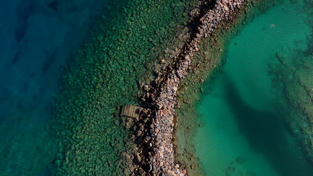 Aerea - Sentiero roccioso che divide acque turchesi e blu intenso, Creta, Grecia