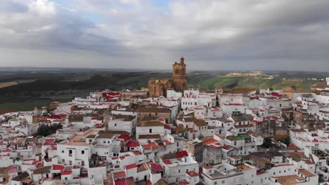 Slow-aerial-cinematic-forwards-over-village-on-top-of-hill-with-church