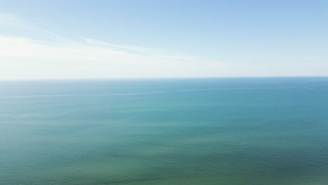 Tranquil-blue-ocean-water-with-soft-white-glow-in-sky,-calm-peaceful-nature-background