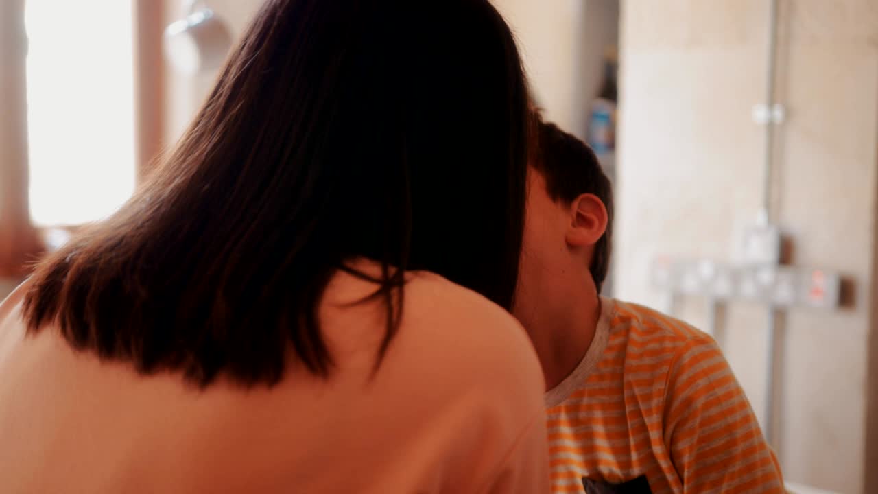 어머니와 아들이 집 주방에서 아침 식사를 즐기고 있습니다.