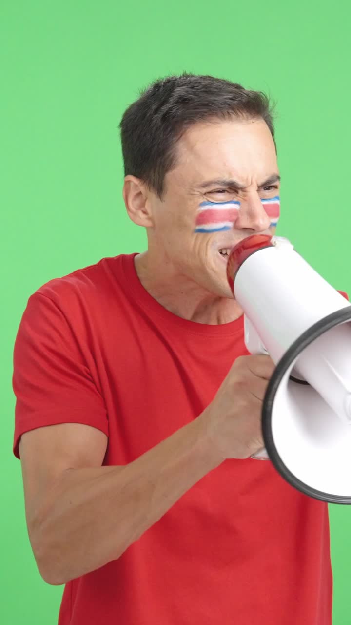 Excited man with costa rican flag on face using a megaphone