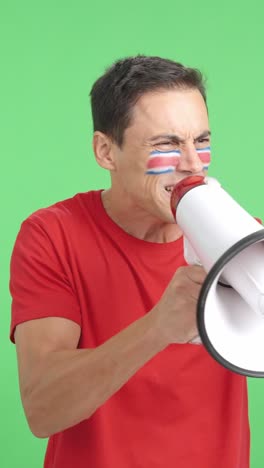 excited man with costa rican flag on face using a megaphone