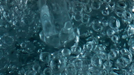 bubbling beverage filling glass closeup. top view diverse air bubbles rising