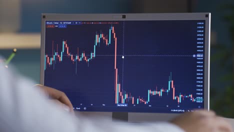 Man-checking-Bitcoin-price-chart-on-digital-stock-market-on-laptop,-cryptocurrency.