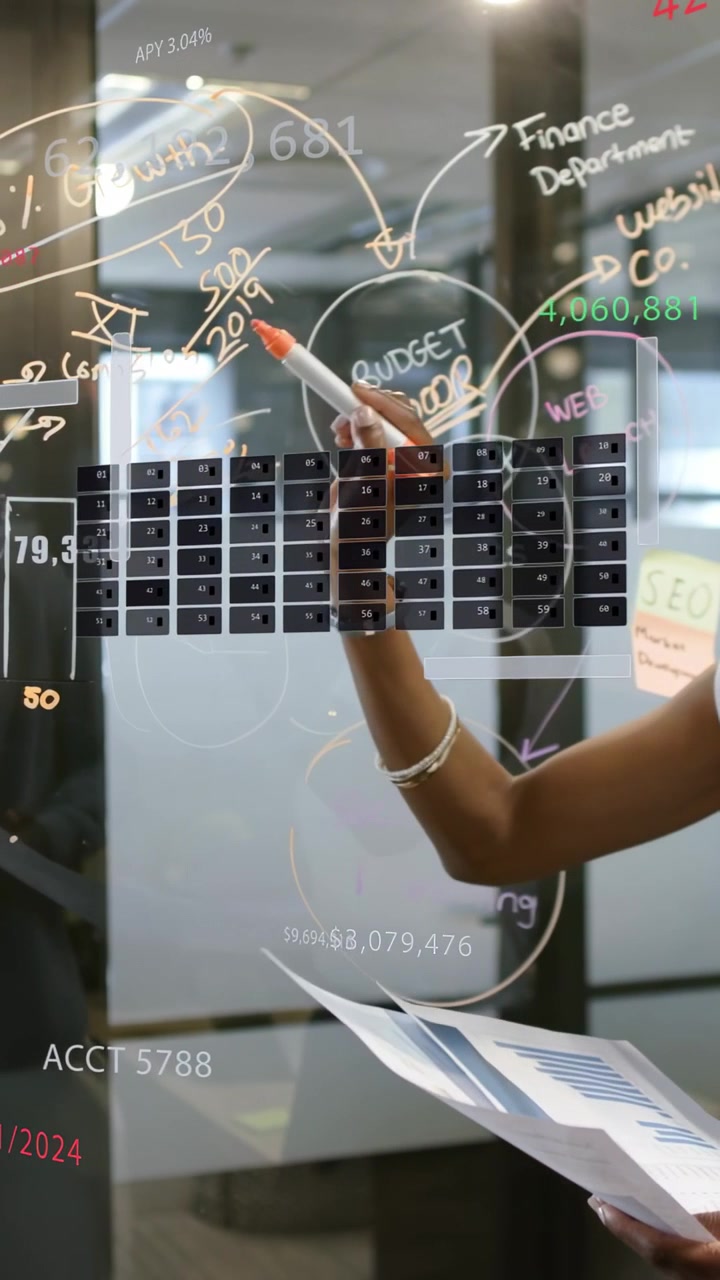 Vertical video: Analyst with charts, circling budget on glass grid, aligning finance plan