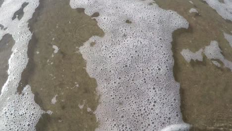 the sea flows over the beach from top left