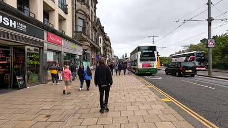 pedestrians and buses on a bustling street