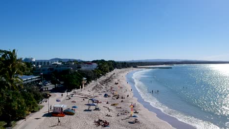 aerial-view-of-busy-Noosa-Main-Beach,-Noosa-Heads,-Queensland,-Australia