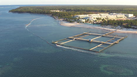 Wide-angle-aerial-of-a-powerboat-approaching-a-beautiful-resort,-Punta-Cana,-Dominican-Republic