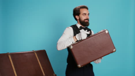 bellboy carries trolley bags in studio