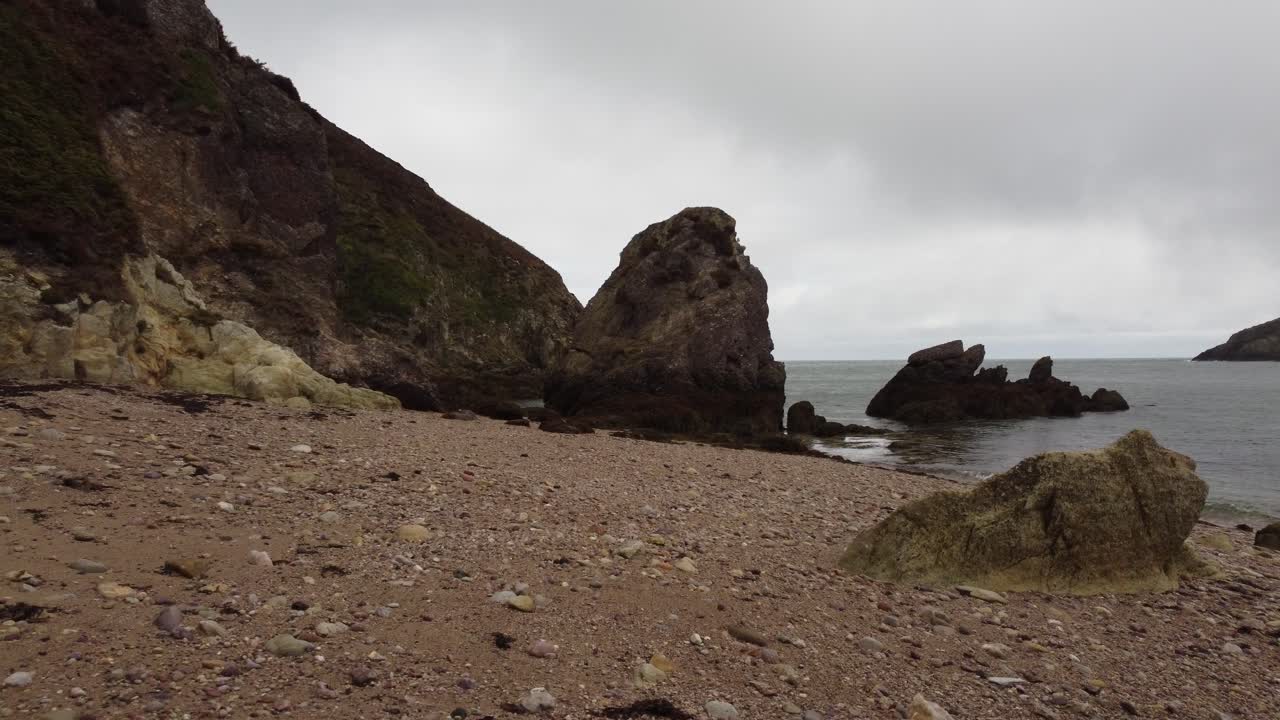 drone volando a baja altura sobre una hermosa playa rocosa, porth wen, reino unido