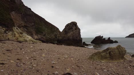 Drone-Flying-Low-Over-Beautiful-Rocky-Beach,-Porth-Wen,-United-Kingdom