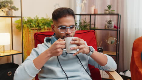 man enjoying a cup of coffee and relaxing in a chair.